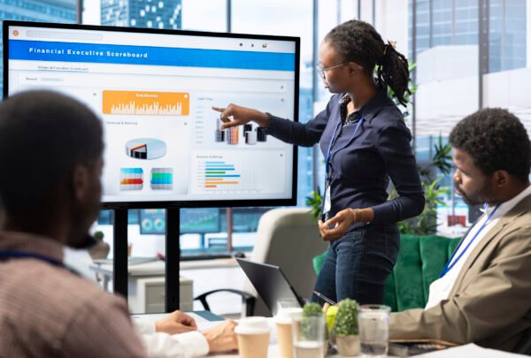 Advisory board members and team leaders gathering to review project outcomes, discuss resource allocation to ensure objectives achievement. Diverse business associates in a meeting.