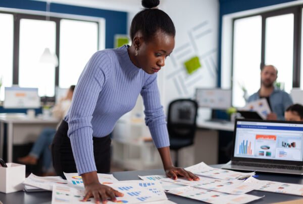 Black businesswoman checking work of multiethnic colleagues in startup agency. Diverse team of business people analyzing company financial reports from computer. Start up Successful corporate professional entrepreneur online internet statistics