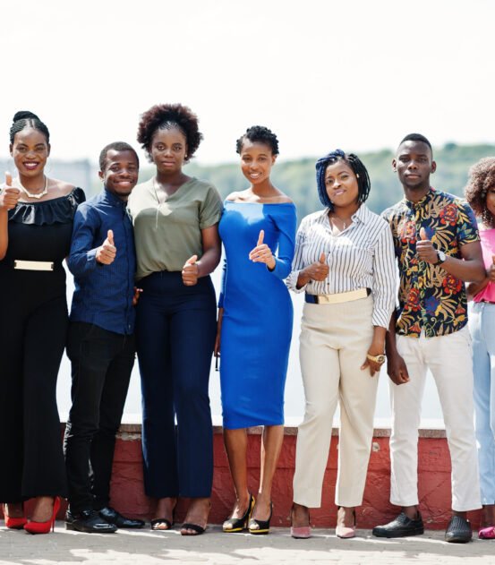 Group of ten african american people posed at street of city. Fashionable people of Africa shows thumb up.