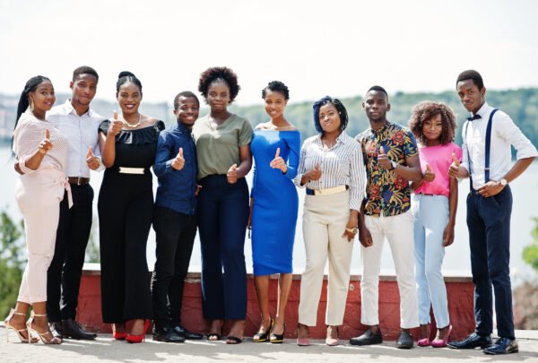 Group of ten african american people posed at street of city. Fashionable people of Africa shows thumb up.
